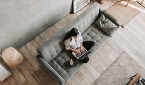 woman working from home on couch with coffee