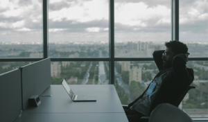 man leaning back in chair in office with computer